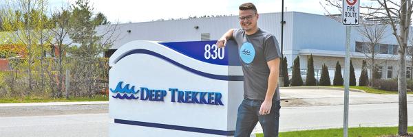 Cody Warner next to Deep Trekker sign